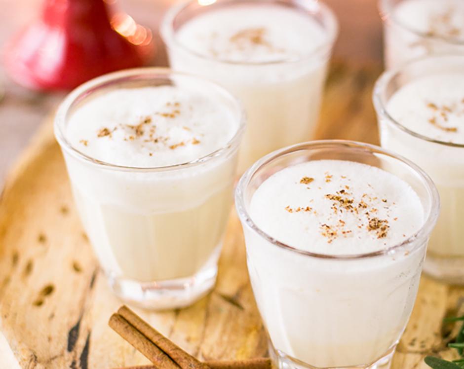 Fresh homemade eggnog recipe made with Raven's Nest mulling spice garnished with fresh cinnamon sticks and nutmeg for a Christmas party or holiday cocktail hour